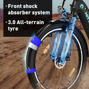 Electric mountain bike's front wheel with a shock absorber system and 3.0 all-terrain tire, highlighted by blue dynamic lines to showcase the suspension's motion, set against a rugged desert background.