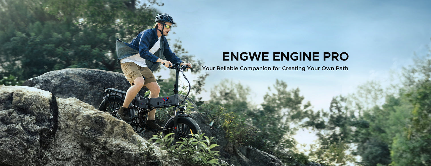 Man riding the ENGWE ENGINE PRO electric bike over rocky terrain, demonstrating the bike's off-road capabilities. The image conveys the bike as 'Your Reliable Companion for Creating Your Own Path' in an outdoor setting.